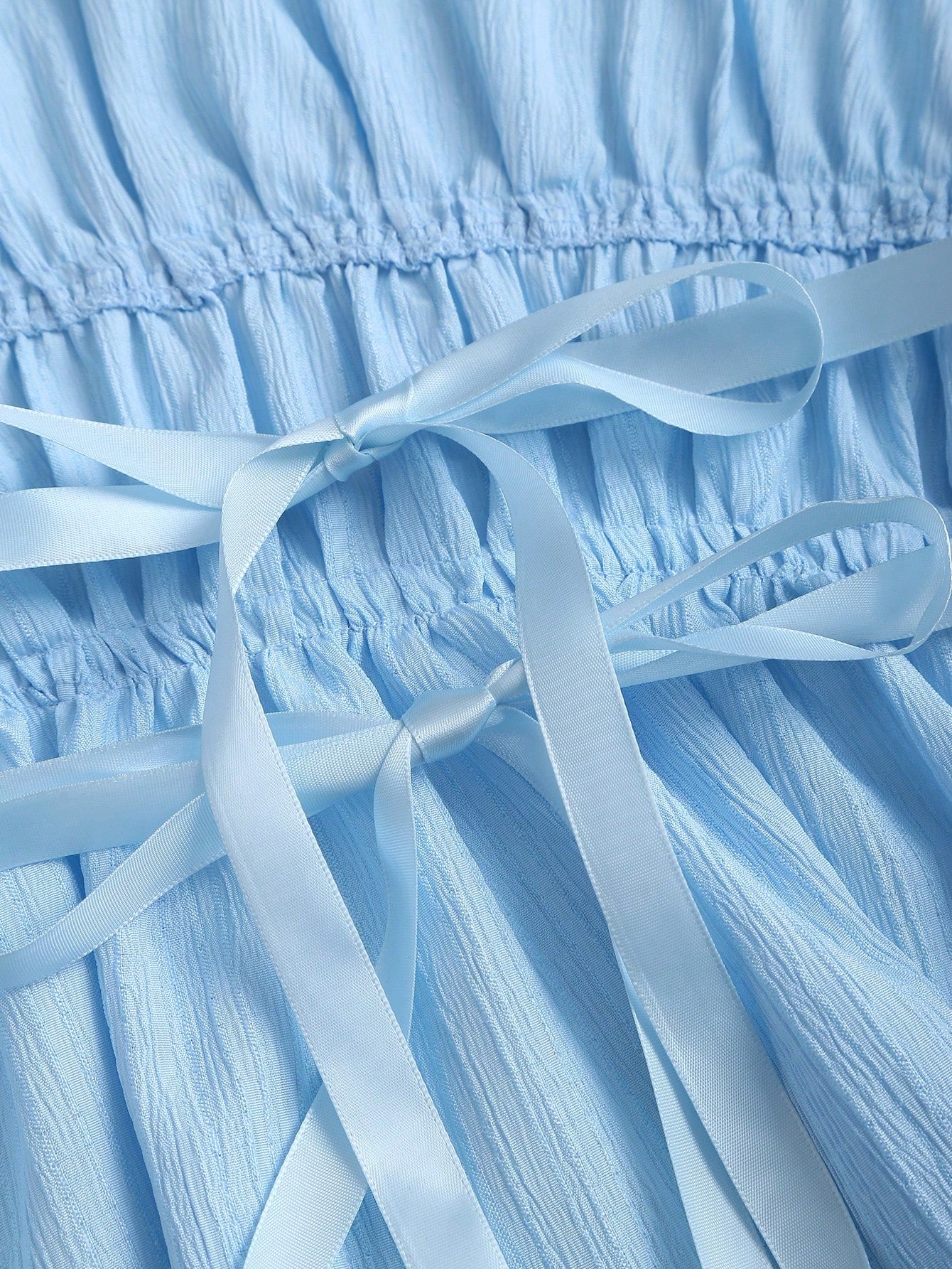 Close-up of light blue fabric with ribbons