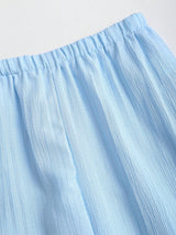 Close-up of a light blue skirt with a plain background