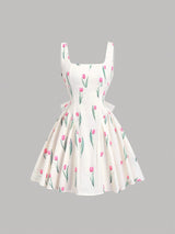 White dress with pink floral pattern on a gray background