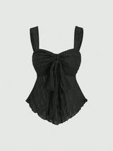A black crinkled lace camisole top with wide shoulder straps, a sweetheart neckline, and a large front bow detail, shown against a light gray background.