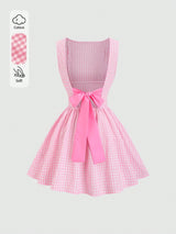 A pink and white gingham sleeveless dress with a large pink ribbon bow at the waist, shown on a light gray background with a small cotton and softness feature callout on the left.