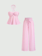A two-piece women's outfit set featuring a pink and white vertically striped halter crop top with a sweetheart neckline and ruffled bust, paired with matching wide-leg cropped pants with a drawstring waist.
