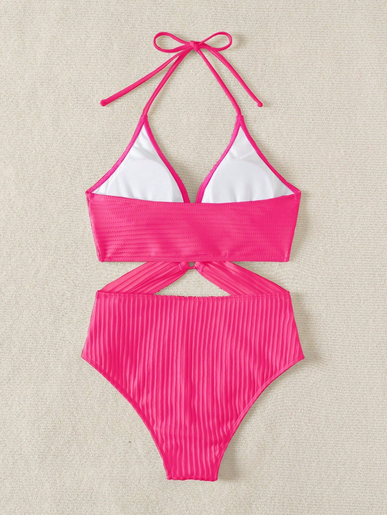 Pink bikini set with white top on a beige background