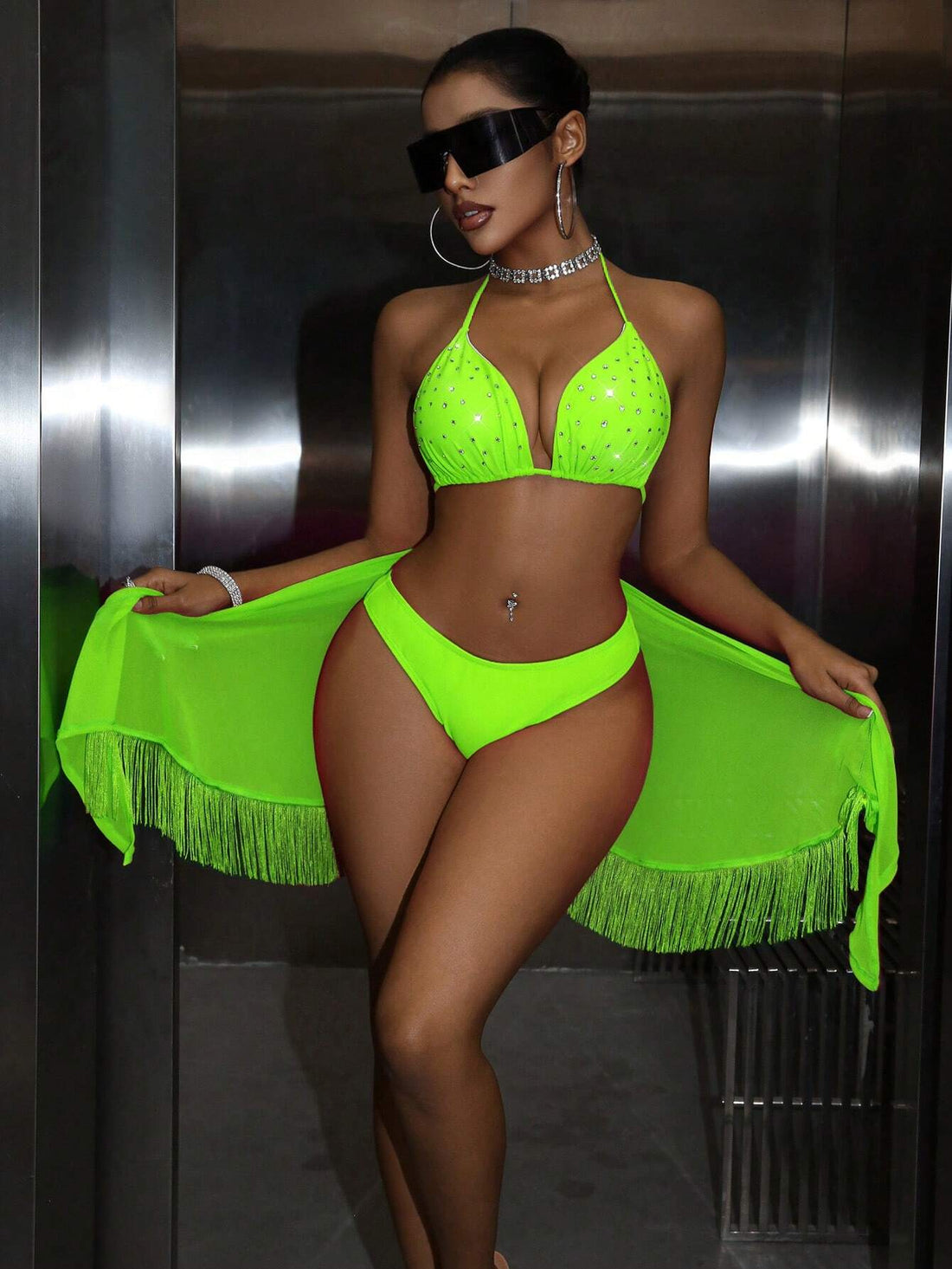 Woman wearing a neon green bikini with a matching shawl against a metallic background