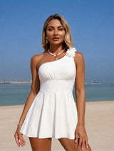 Woman in a white dress with a flower detail on a beach