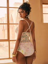 Woman wearing a floral swimsuit in a sunlit room.