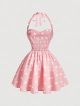 Pink polka dot dress with a halter neck on a light gray background