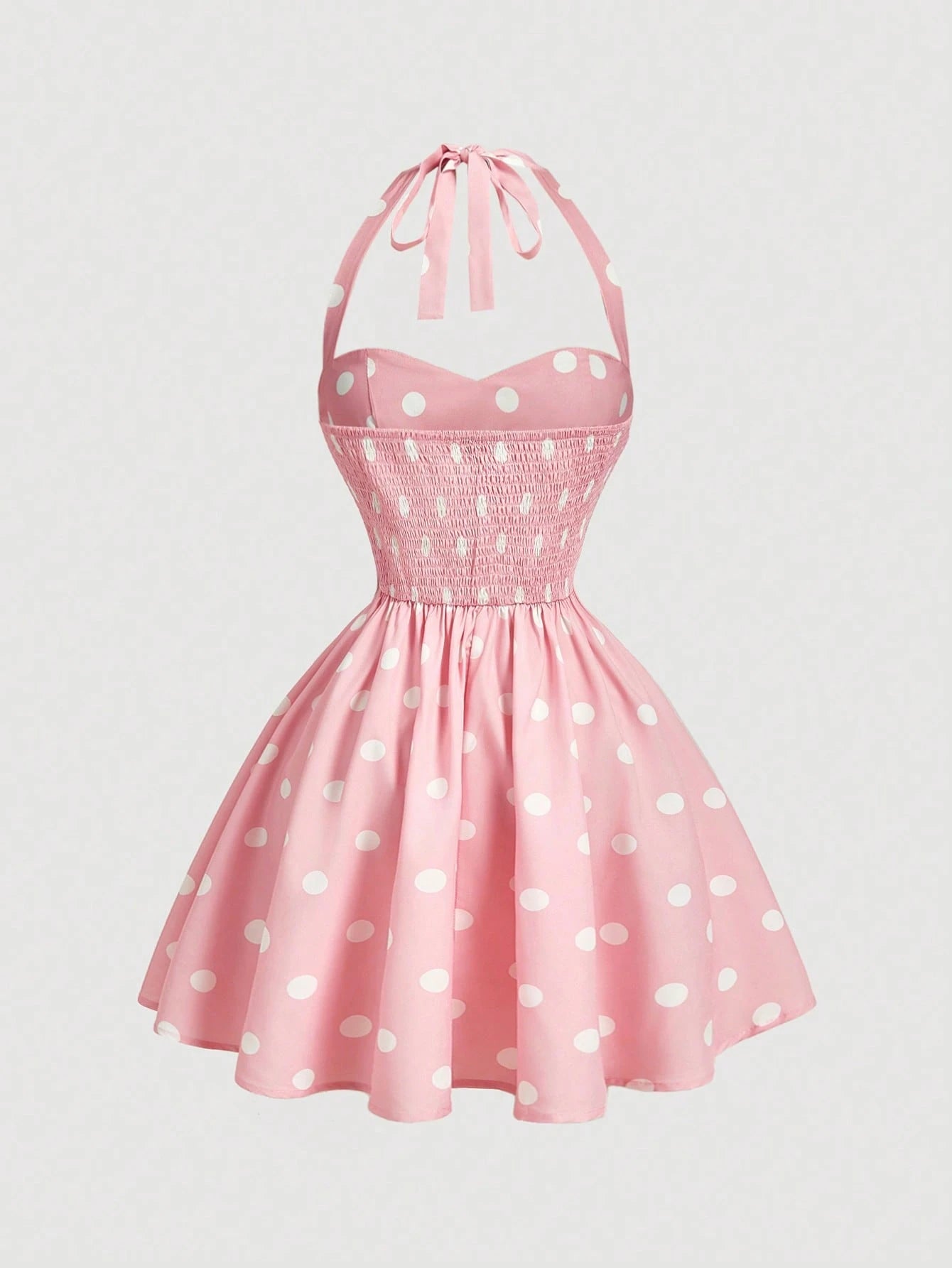 Pink polka dot dress with a halter neck on a light gray background