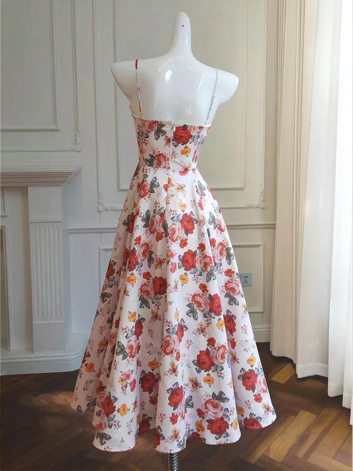 Floral dress on a mannequin against a neutral wall.