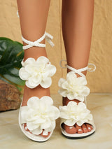 White floral sandals on a neutral background