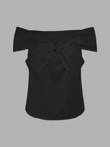 Black off-shoulder top with a bow detail on a gray background
