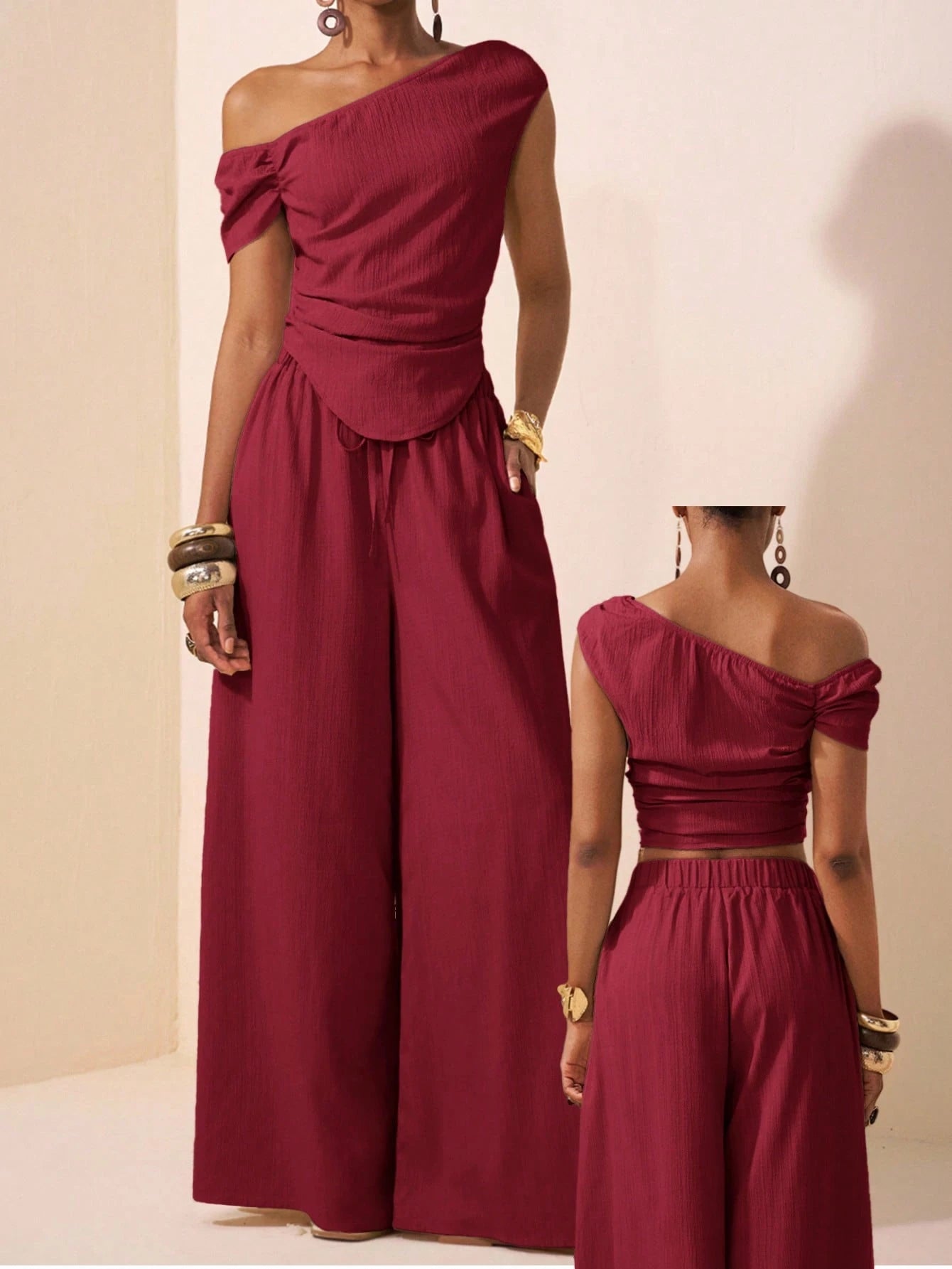 Two women wearing matching burgundy outfits against a beige background