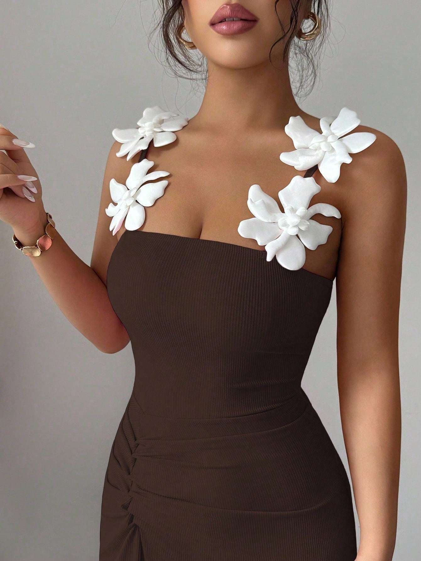 Brown dress with white floral embellishments on a neutral background